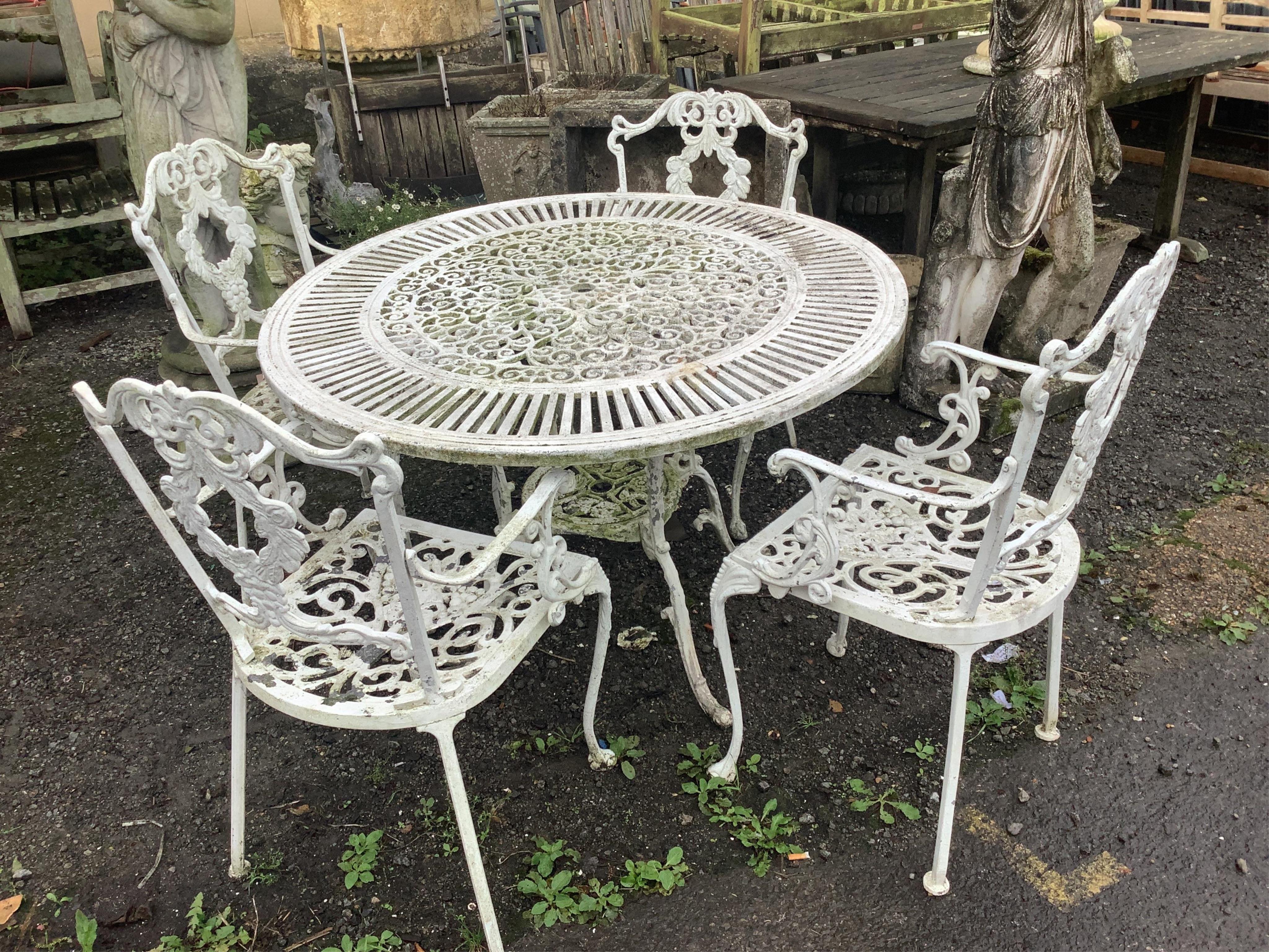 A Victorian style painted aluminium circular garden table, diameter 106cm, height 70cm and four chairs. Condition - good